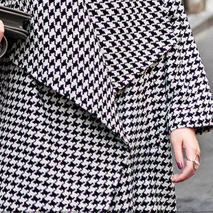 Feiner schwarz-weiß karierter Wintermantel mit übergroßen Taschen und langem Mantel. Feiner Trenchcoat mit Kerbmuster