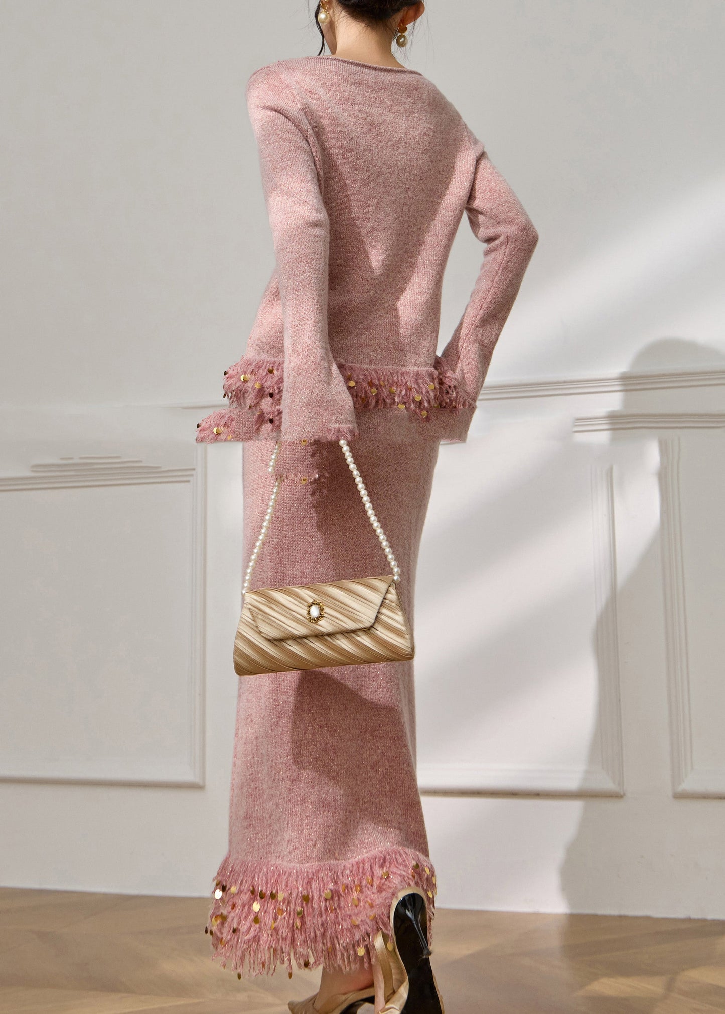 Conjunto de dos piezas de jersey de punto de algodón con borlas y falda larga con retazos de lentejuelas rosas francesas y mangas acampanadas.