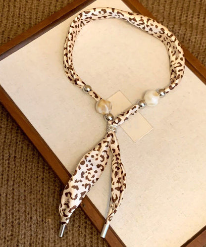 Collar con colgante de bufanda tejida con cuentas y estampado caqui hecho a mano