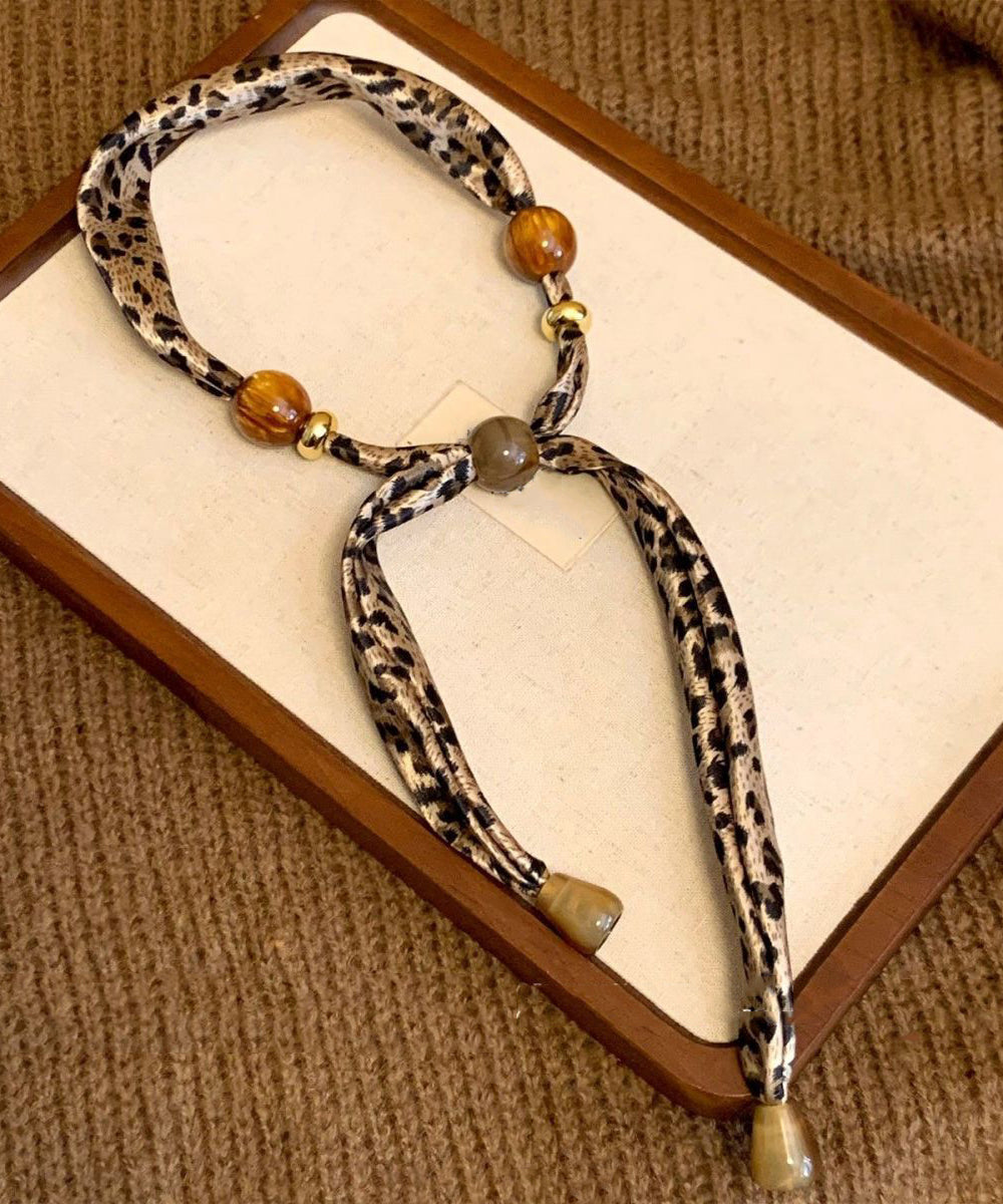 Collar con colgante de bufanda tejida con cuentas y estampado caqui hecho a mano