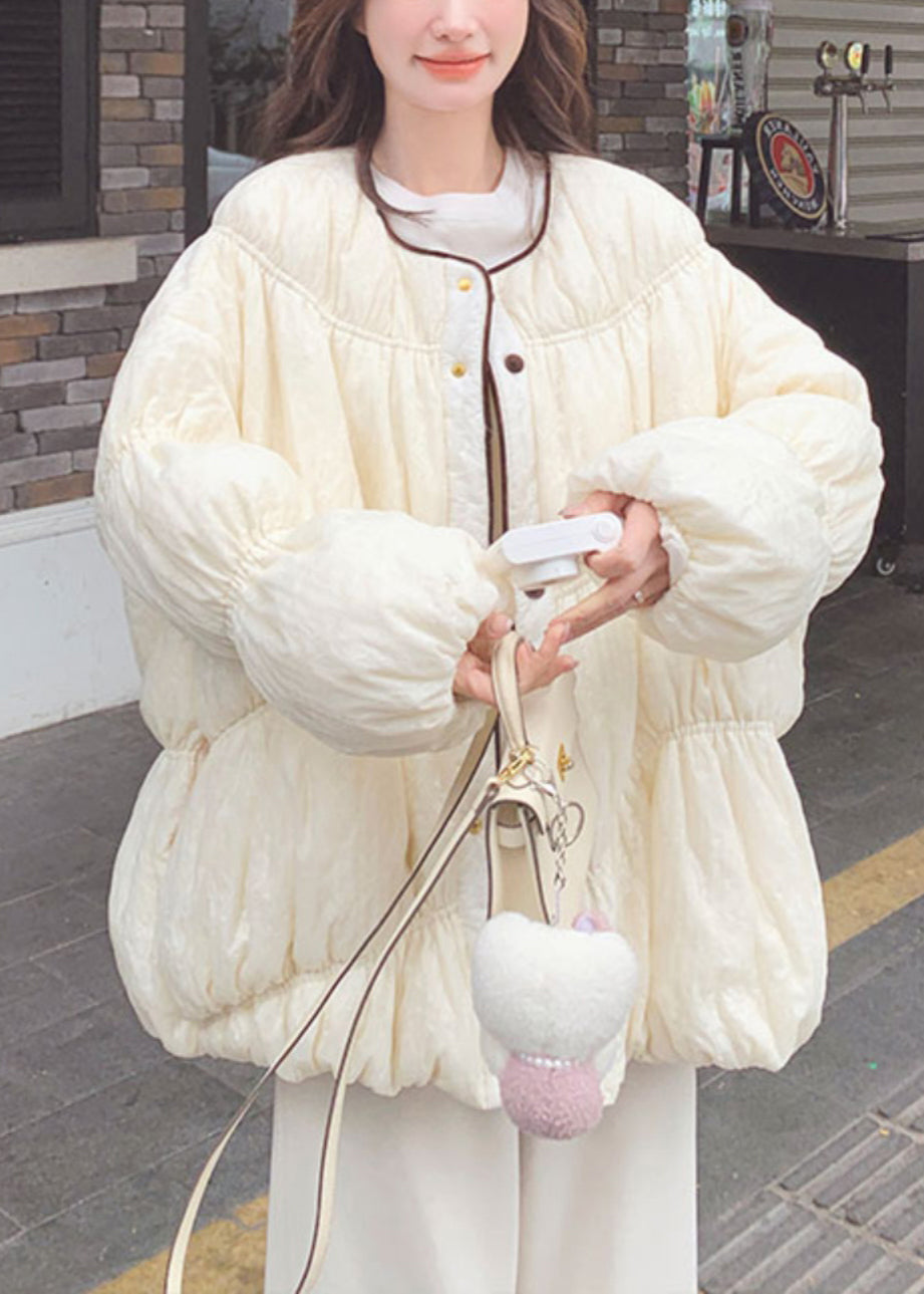 Locker geschnittener, beigefarbener Mantel mit Rundhalsausschnitt, Knopfleiste, Taschen und Laternenärmeln aus Entendaunen.