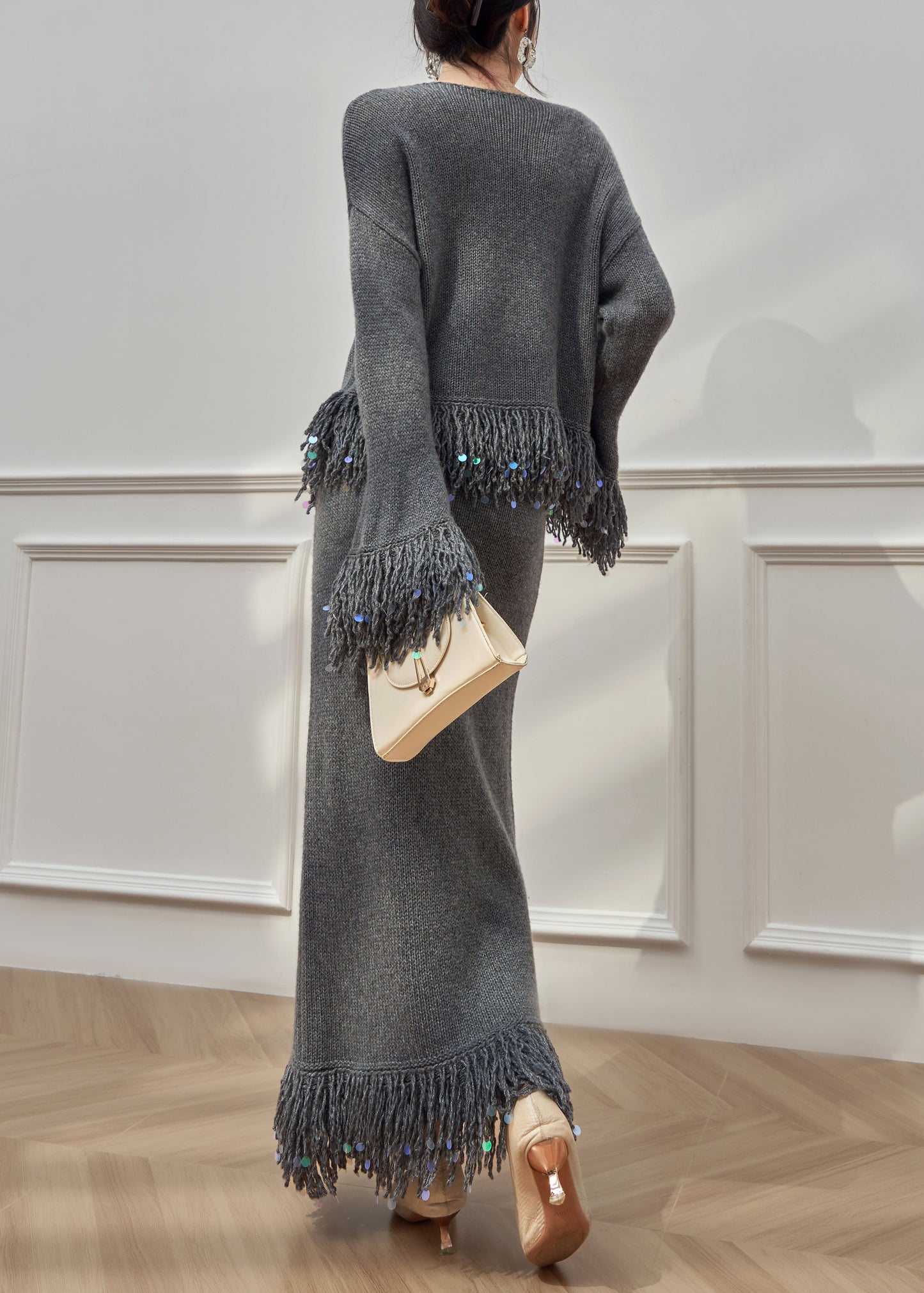 Locker sitzender, grauer Strickpullover und Rock mit Rundhalsausschnitt und Quasten, zweiteilig, mit ausgestellten Ärmeln
