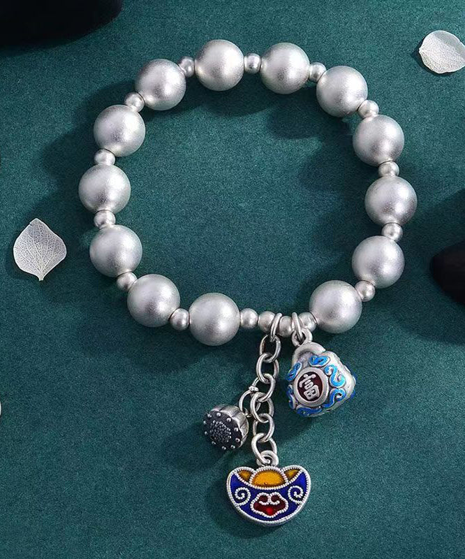 Pulsera suelta de seda con dijes cloisonné y cobre plateado