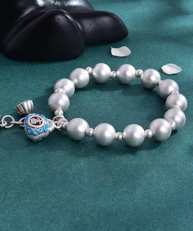 Pulsera suelta de seda con dijes cloisonné y cobre plateado