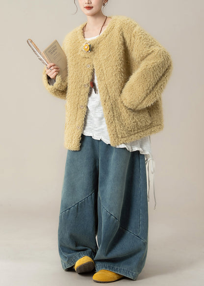 Weit geschnittener gelber Mantel mit Taschen und weite Jeanshose mit Teddy-Kunstfell-Zweiteiler für den Winter