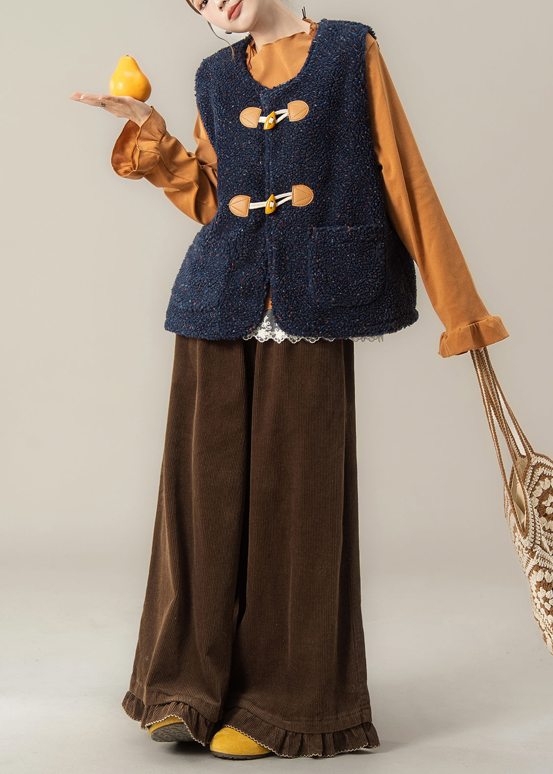 Conjunto de 3 piezas de invierno con chaleco azul marino moderno y camiseta naranja y pantalones café.