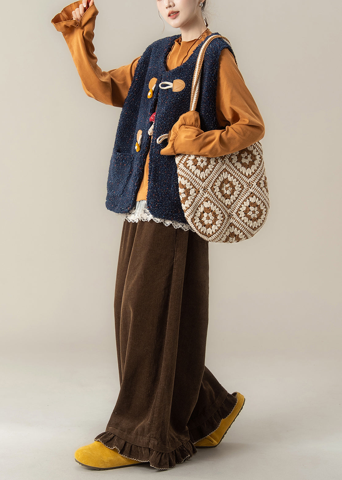 Conjunto de 3 piezas de invierno con chaleco azul marino moderno y camiseta naranja y pantalones café.