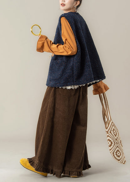 Conjunto de 3 piezas de invierno con chaleco azul marino moderno y camiseta naranja y pantalones café.