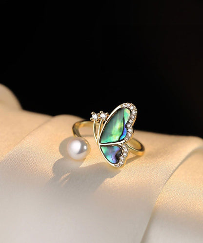 Conjunto de tres piezas de collar, anillos y pendientes colgantes con colgante de mariposa, perla y circonita dorada y cobre dorado.