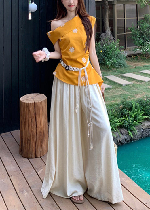 Conjunto de dos piezas de algodón con top amarillo con hombros descubiertos y pantalones beige de pierna ancha para verano