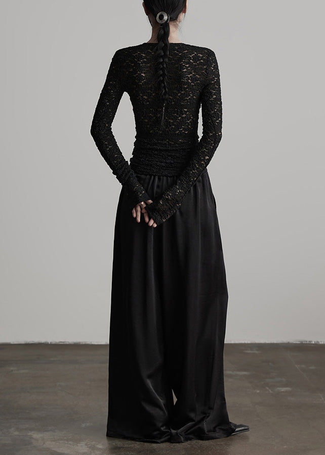 Pantalones de seda negros con cintura elástica y arrugas para primavera.