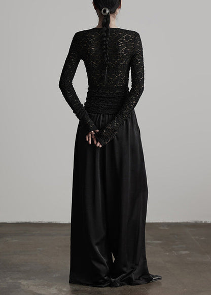 Pantalones de seda negros con cintura elástica y arrugas para primavera.