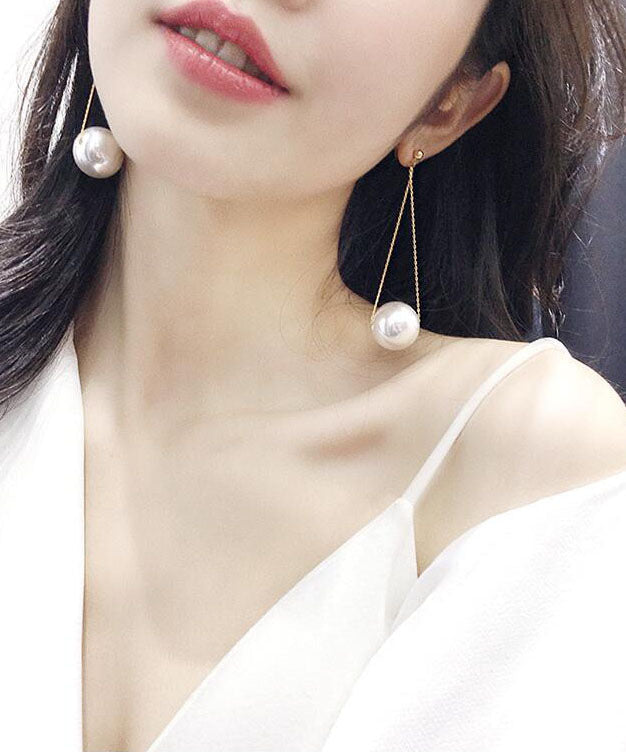 Elegantes pendientes colgantes de perlas doradas y plata de ley