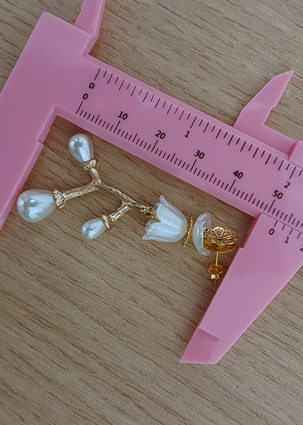 Elegantes aretes colgantes de rama de oro de 14 quilates con perla blanca