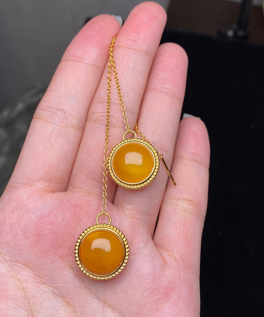 Elegantes pendientes colgantes de cera de abeja con flores incrustadas en plata de ley amarilla