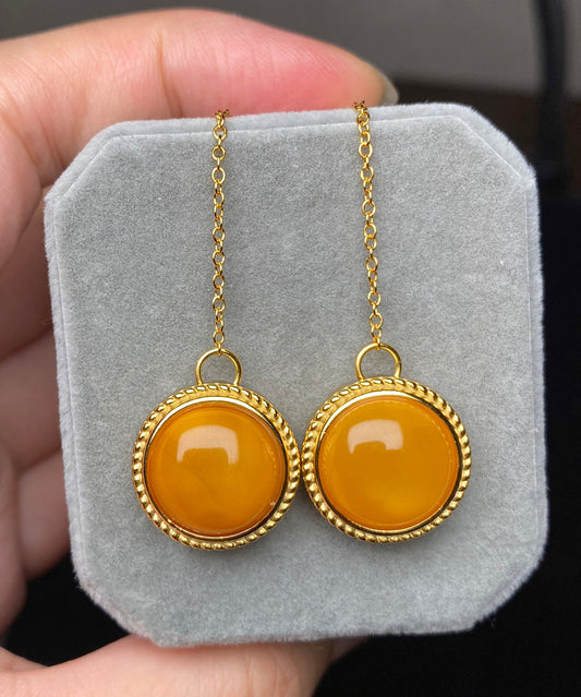 Elegantes pendientes colgantes de cera de abeja con flores incrustadas en plata de ley amarilla