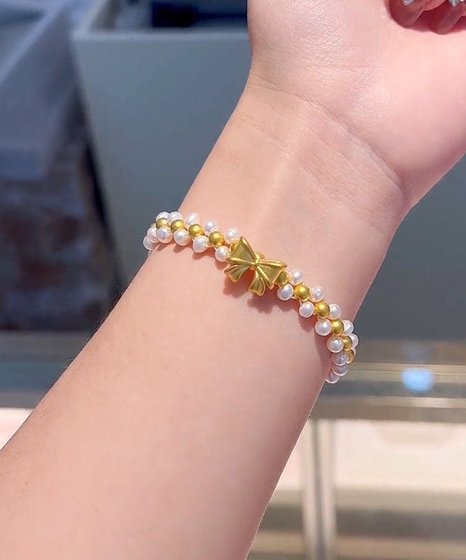 Elegante pulsera con dije de lazo de perlas tejidas a mano en amarillo y blanco