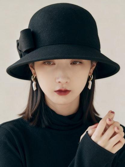 Elegante sombrero cloche de lana con lazo negro y rizo
